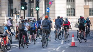 Group of cyclists wearing backpacks at traffic lights on a central London street