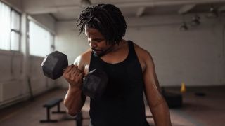 Man performs biceps curl arms exercise with dumbbell