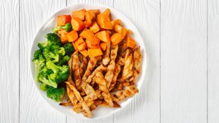 Plate of chicken strips, broccoli and cubes of sweet potato